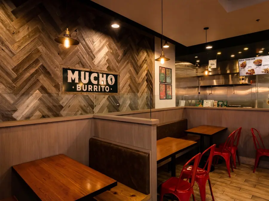 Booth seating under the Mucho Burrito sign on a herringbone wood wall, Burnaby